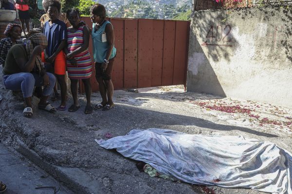 Des habitants se rassemblent devant une personne qui, selon eux, a été tuée lors d'une attaque perpétrée par des membres d'un gang, dans le quartier de Pétion-Ville à Port-au-Prince (Haïti) - 19/11/2024.