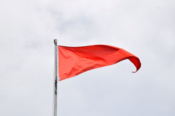 Drapeau rouge levé, à Magenta plage, image d'illustration.