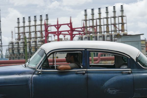 Un homme au volant d'une voiture américaine classique devant un générateur qui ne produit plus d'électricité depuis des jours à La Havane, Cuba, le vendredi 18 octobre 2024.