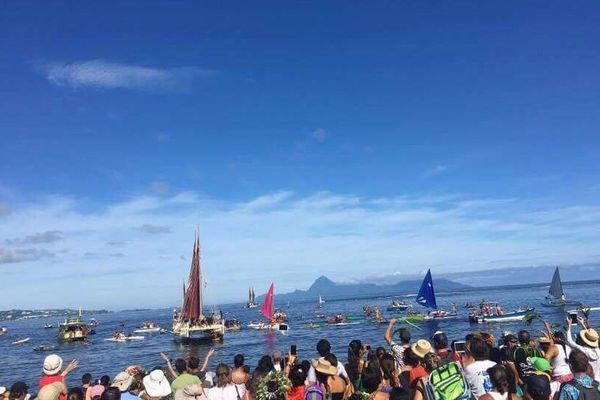 Les spectateurs accueillent la pirogue sur la plage de la Pointe Vénus