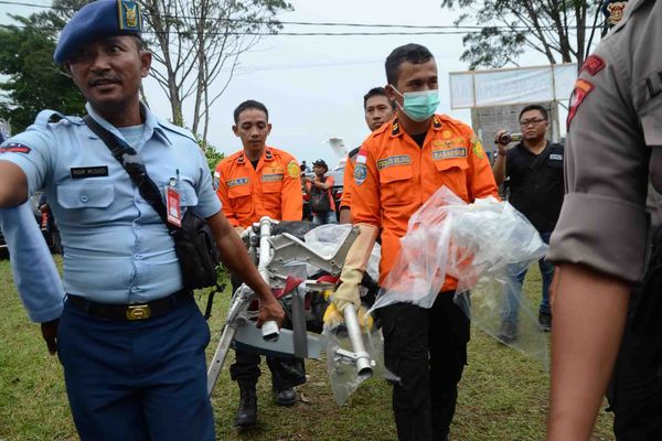 Des officiers indonésiens récupèrent des pièces de l'avion après le crash en mer de Java fin 2014.