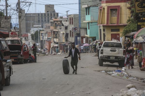 Un homme roule un pneu, dans une rue de Port-au-Prince (Haïti), une ville où les gangs font leur loi et où la population n'est pas en sécurité - 17/10/2024.