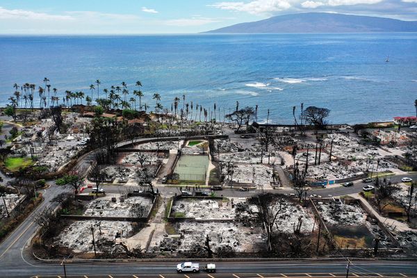 Un véhicule de dépannage passe devant des structures et des voitures brûlées deux mois après un incendie de forêt dévastateur à Lahaina, à Hawaï. L'incendie de forêt du 8 août 2023, provoqué par le vent, avait tué au moins 98 personnes, déplacé des milliers d'autres et détruit plus de 2 000 bâtiments dans la ville historique, dont la plupart étaient des maisons.