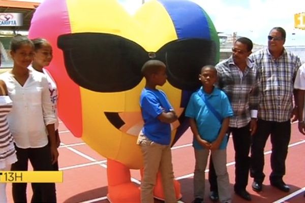 Attroupement devant la mascotte des Carifta Games, en forme de coeur.