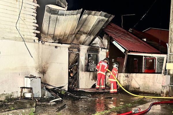 Les pompiers de Cayenne s'affairent à éteindre les flammes dans une maison du quartier de La Matiñe, touchée par un incendie criminel, le 2 août.