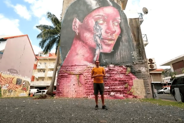 Le graffeur Steek oner devant une de ses fresques