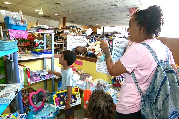 Une famille devant les jouets de seconde main vendus à la Ressourcerie de Nouméa.