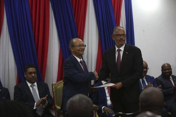 Le nouveau Premier ministre haïtien Alix Didier Fils-Aimé, à droite, serre la main du président du Conseil de transition Leslie Voltaire lors de sa cérémonie d'investiture à Port-au-Prince, Haïti, le lundi 11 novembre 2024.