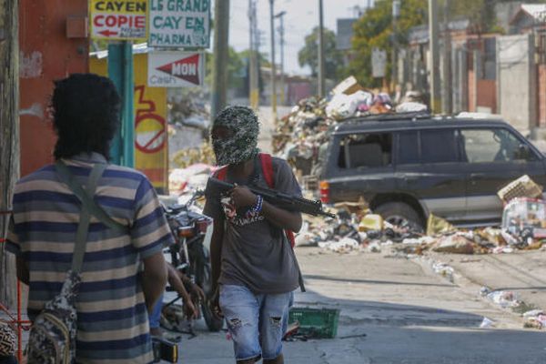 Des membres armés du gang G9 montent la garde à leur barrage routier à Port-au-Prince, Haïti, lundi 11 mars 2024.