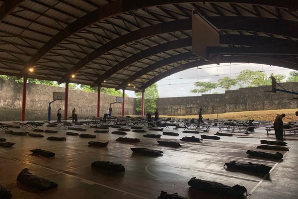 Installation de lits picots par les militaires au hall au collège Justin Catayée de Cayenne pour accueillir 250 sinistrés de l'incendie du squat de Baduel