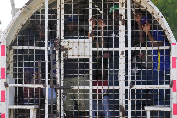 Des Haïtiens sans papiers, détenus par les agents de l'immigration, se tiennent à bord d'un véhicule de police, à Dajabon (République dominicaine) - 17/05/2024.