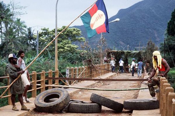 Des militants du (FLNKS) occupent un pont et dressent un barrage, près de Thio, le 29 novembre 1984. Quelques jours auparavant, le 18 novembre 1984, le leader indépendantiste Eloi Mahoro avait défoncé une urne à coups de hache pour illustrer symboliquement la détermination des indépendantistes Kanaks à boycotter "activement" les élections territoriales. 