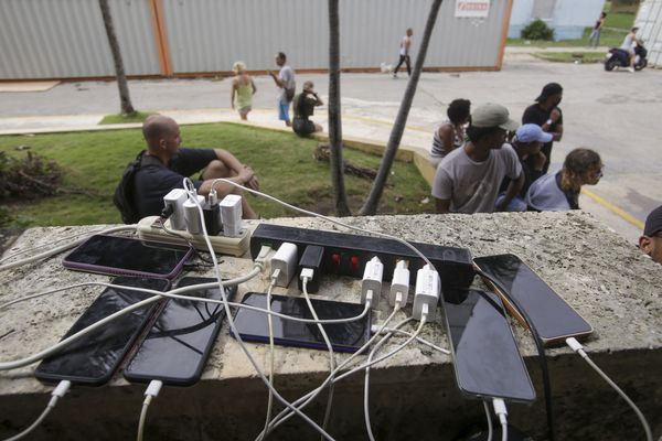 Des habitants chargent leurs téléphones après l'ouragan Rafael, jeudi 7 novembre 2024