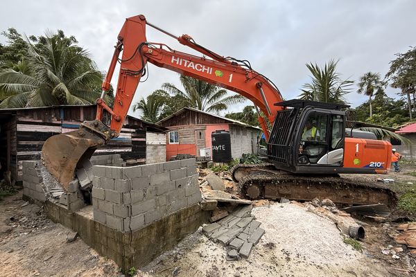 Un tractopelle en action lors de la démolition d’une habitation dans le quartier Malgache.