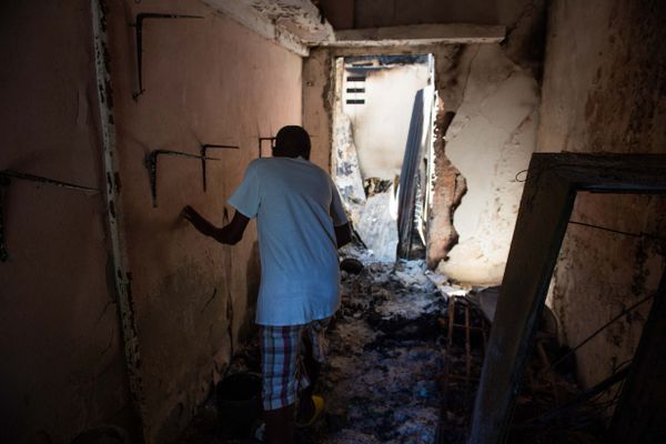 Un homme entre dans sa maison incendiée par des gangs armés à Poste Marchands à Port-au-Prince, Haïti, le 9 décembre 2024.