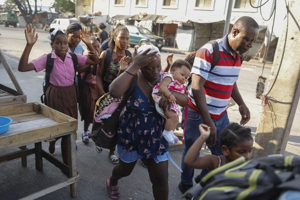 Des habitants fuient leurs maisons lors d'affrontements entre la police et un membre d'un gang dans le quartier du Portail, à Port-au-Prince (Haïti) - 29/02/2024.