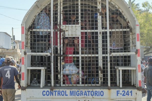 Des personnes détenues en vue d'être expulsées vers Haïti se tiennent à bord d'un camion de police sur le pont frontalier qui relie Dajabon, en République dominicaine, à Haïti, le lundi 18 mars 2024. (AP Photo/Ricardo Hernandez)