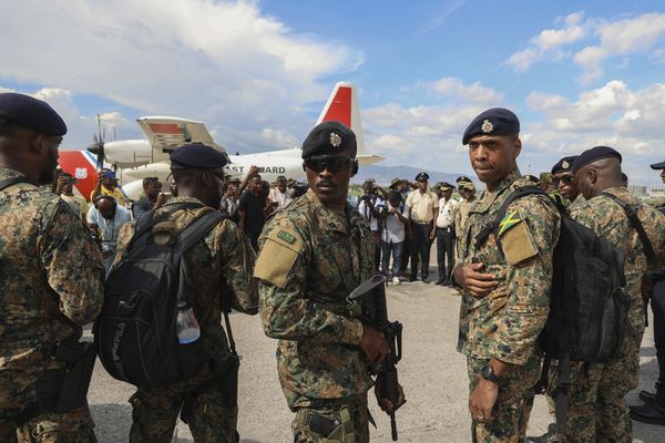 Des policiers de la Jamaïque et du Belize se tenant sur le tarmac après leur arrivée à l'aéroport international Toussaint Louverture de Port-au-Prince, Haïti, jeudi 12 septembre 2024.