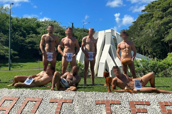 Des joueurs de rugby nus, en train de prendre la pose dans un rond-point du Diamant en Martinique.