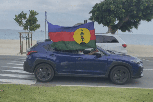 Le passager d'une voiture brandit le drapeau indépendantiste le 24 septembr à l'Anse-Vata, à Nouméa.