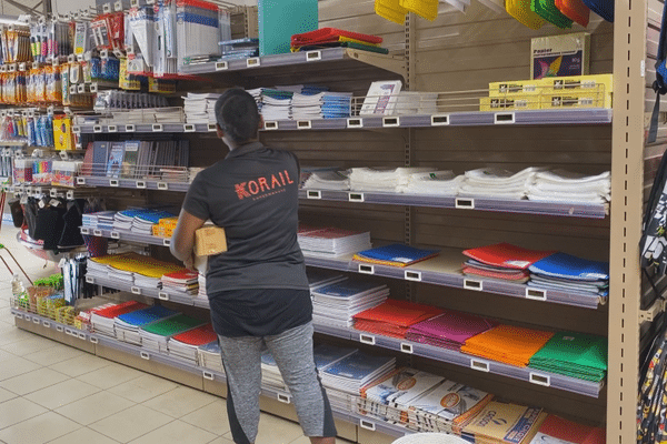 Une employée réapprovisionne les rayons d'un magasin à Lifou