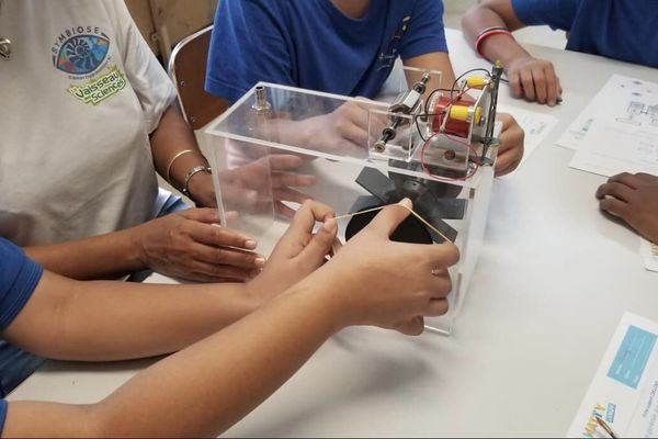 Des enfants manipulent un engin électrique, au sein des locaux de l'association Symbiose.