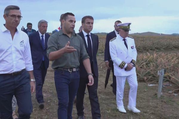 David Moulin guidant Emmanuel Macron sur son exploitation agricole, à Moindou, le 25 juillet 2023.
