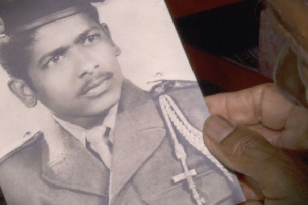 Edgar Latchoumanin regarde une photo de lui, jeune soldat en Algérie