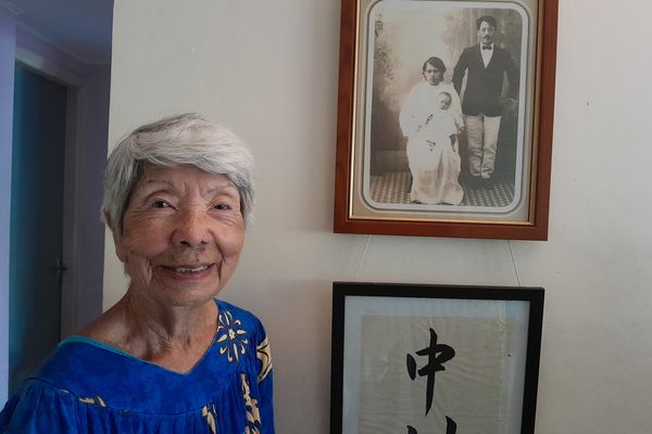 Sophie Nakamura devant un cliché de ses parents juste mariés : Marianne Wamytan, alors fille du chef de Saint-Louis et monsieur Nakamura, Japonais venu travailler dans les mines à Thio juste avant la Première Guerre mondiale.