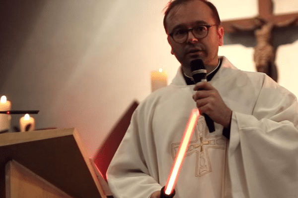 Le prêtre Nicolas Guillou avec un sabre Star Wars lors de la messe de Noël, à Saint-Eblon, le 24 décembre 2015. 