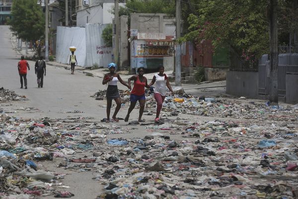 Des gens marchent dans une rue couverte de détritus au centre-ville de Port-au-Prince, en Haïti, le jeudi 5 septembre 2024.