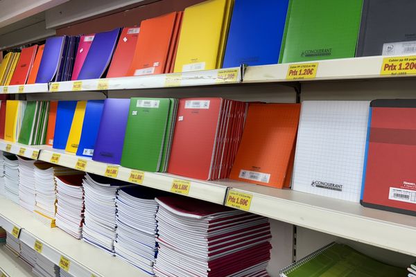 Un rayon de cahiers bien approvisionné à la librairie Le Toucan, offrant un choix varié aux parents et élèves pour la rentrée scolaire.