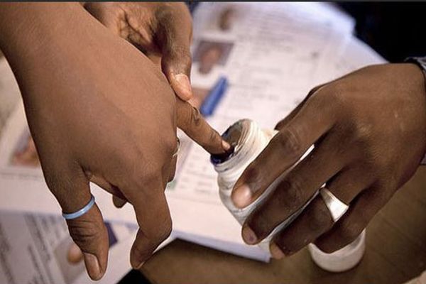 Un électeur trempe son doigt dans un pot d'encre pour confirmer son passage aux urnes.
