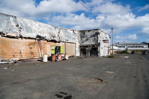 La vie a repris dans cette rue passante de Ducos mais les ruines restent. Nouméa. Septembre 2024.