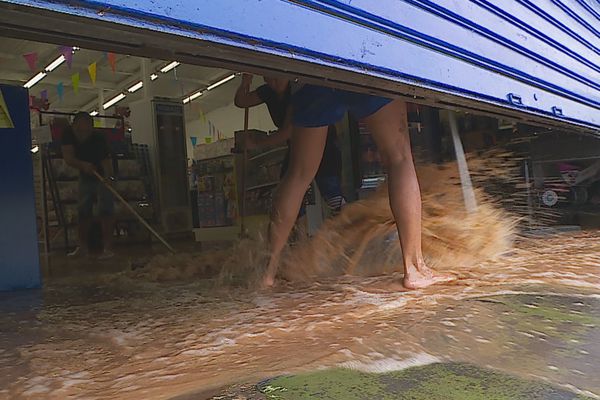 Situé non loin de la rivière, ce magasin a été rapidement inondé. Les employés à pied d'oeuvre pour évacuer l'eau.