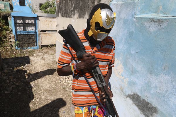 Un membre d'un gang, qui porte un masque de super-héros, pose pour une photo à Port-au-Prince (Haïti) - 13/11.2024.