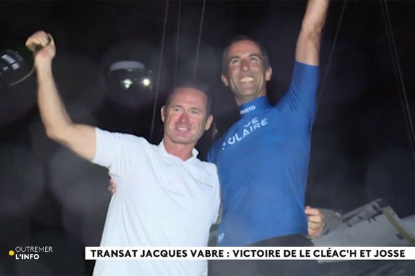 Sébastien Josse (à gauche) et Armel Le Cléac'h (à droite) brandissent des fumigènes après avoir franchi en vainqueurs la ligne d'arrivée de la Transat Jacques Vabre.